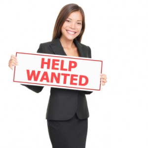 quick-test-coaching-niche professional women holds help wanted sign